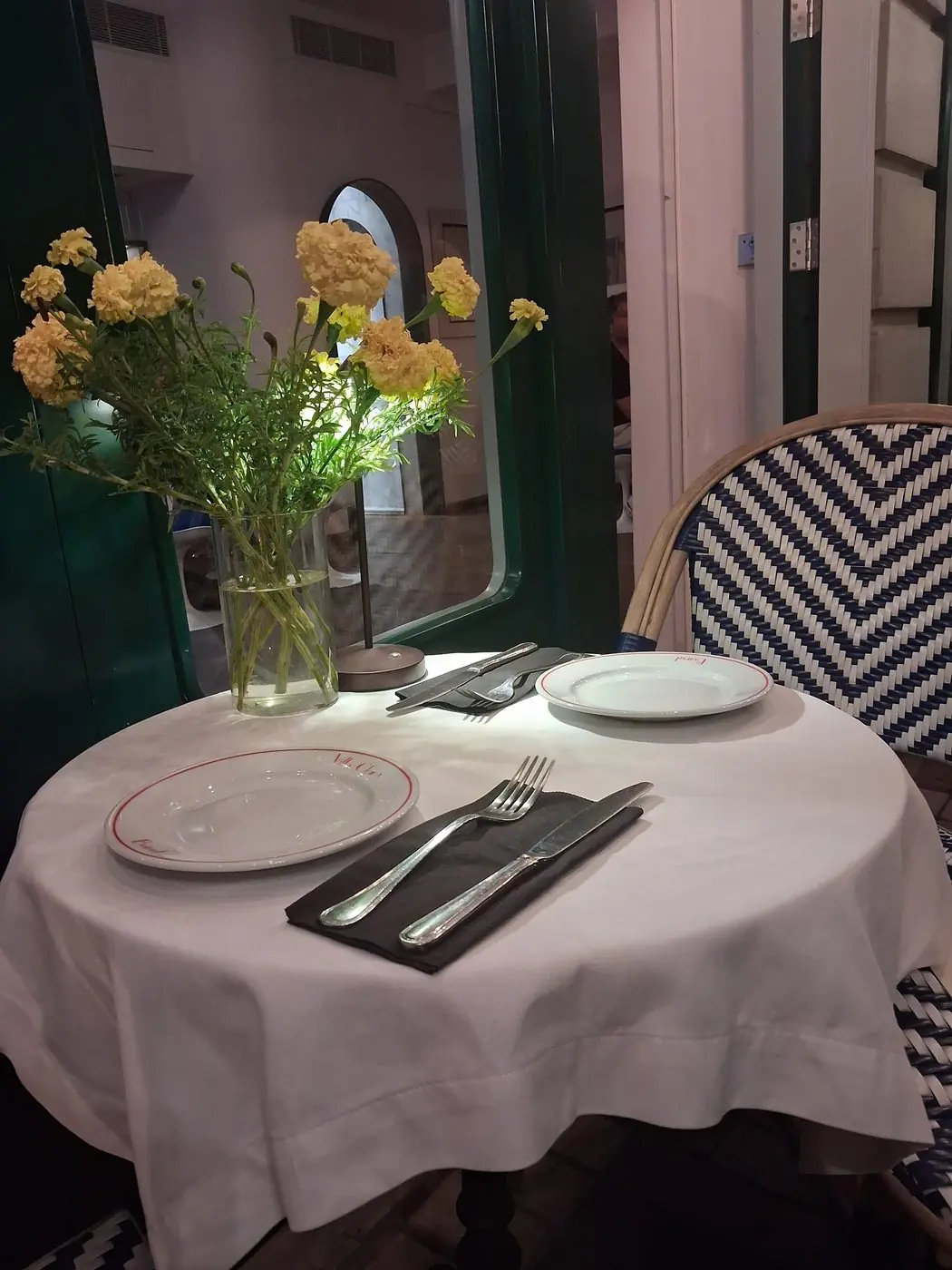 Table dressée et soucis jaunes près de la porte verte