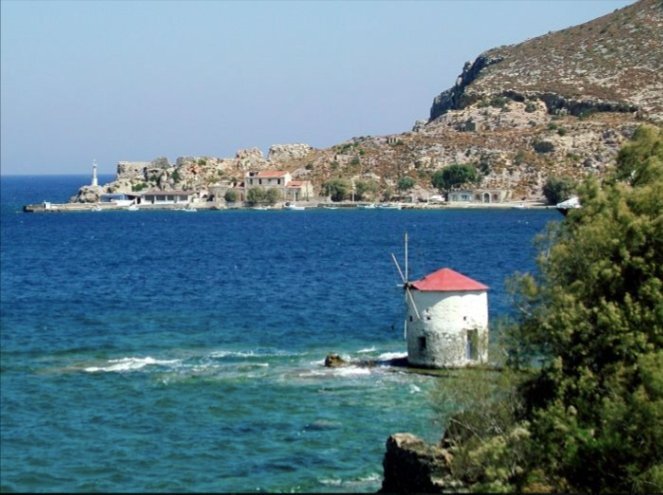 Un moulin à vent au bord de la mer turquoise