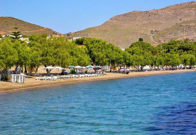 Plage bordée de tamaris avec transats et parasols