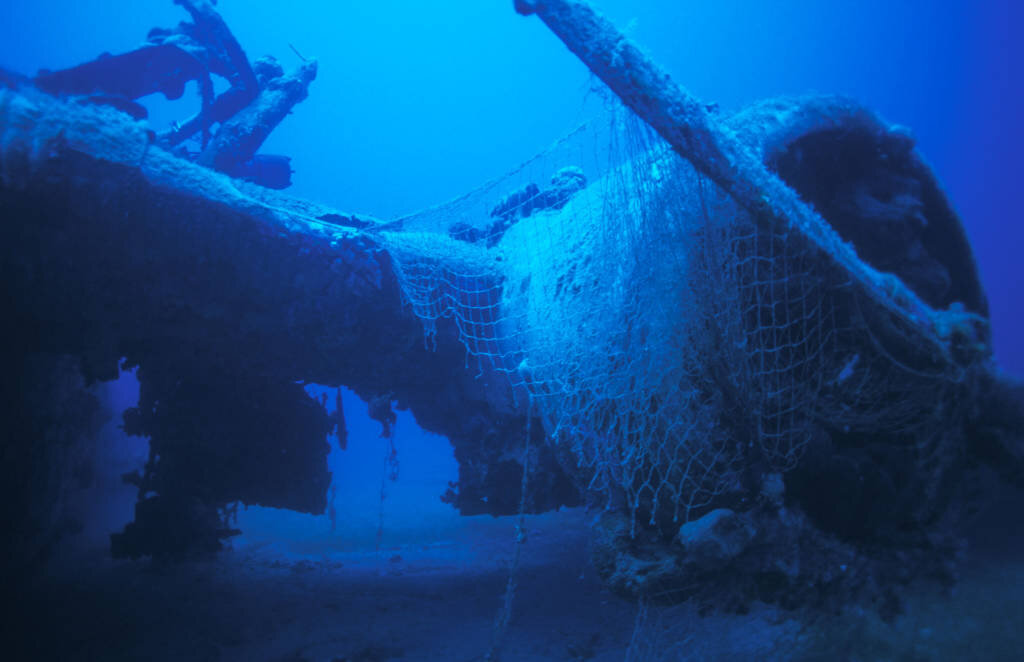 Une épave drapée de filets de pêche fantômes